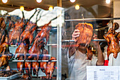 Roast ducks hanging inside a Chinese restaurant window in Bellevue, Paris.