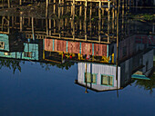 Colorful palafitos or fishermen's stilt houses reflected in an inlet at sunrise in Castro on Chiloe Island, Chile.