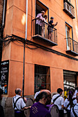 People in balcony watching the Tenth departure of the Cruz de Mayo, May Cross procession, of the Brotherhood of Jesus el Pobre, Madrid, Spain.