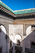 Ein ruhiger Blick durch das verschnörkelte Fenster der Cherratine Madrasa fängt die Essenz von Fez ein. Fez, Marokko.