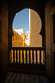Ein ruhiger Blick durch das verschnörkelte Fenster der Cherratine Madrasa fängt die Essenz von Fez ein. Fez, Marokko.