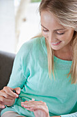 Young Woman Applying Nail Varnish