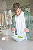 Mann schüttelt Salat
