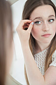 Teenage Girl Looking in Mirror Checking Eye Makeup