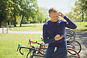 Mature Man in Park Listening to Music on Smartphone