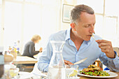 Mature Man Eating Lunch at Restaurant