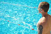 Reifer Mann am Swimmingpool stehend