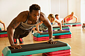 Man Doing Pushups at Step Aerobics Class