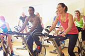 Gruppe von Personen auf dem Heimtrainer im Fitnesskurs