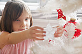 Close up of Young Girl Decorating Christmas Tree