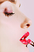 Close up Profile Young Woman Applying Red Lip gloss