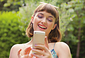 Smiling Teenage Girl Using Smartphone Outdoors