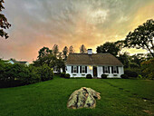 Kaphaus mit Bogendach bei Sonnenuntergang und dramatischem Himmel