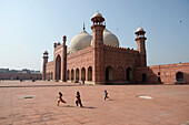 Pakistan,Lahore,children are playing in the inside courtyard of the great Badshahi mosque ,Moghol architecture from the 17th century,the twin sister of the Jama mosque in Delhi
