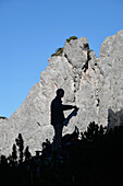 Austria,Styria,ENNSTAL Alps,lynx trail , silhouette of a man holding a hiking map standing out against a clear mountain