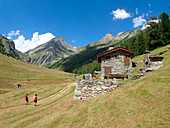 France,Alps,savoie,Vanoise national Park,2 persons are hikking on a mountain trail along a dry stone chalet in the OrgÃ¨re valley dominated bythe DORAN needle 3040m