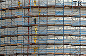 Sultanate of Oman,Oman,DHOFAR, Indian workers in yellow overalls stand on huge scaffolding at Salalah port