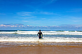 San Sebastian,Spanien - 07. September 2019 - Blick auf einen Surfer, der die Wellen beobachtet