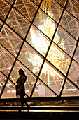 Paris. 1st district. Louvre Museum by night. The pyramid (architect: Ieoh Ming Pei) and Throne sculpture by Kohei Nawa in the background. In the foreground Chinese tourist posing for a photographer.Mandatory credit of the architect architect: Ieoh Ming Pei