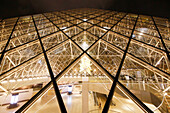 Paris. 1st district. Louvre Museum by night. The pyramid (architect: Ieoh Ming Pei) after the closure: an employee is about to take the big escalator. Throne sculpture by Kohei Nawa.Mandatory credit of the architect architect: Ieoh Ming Pei