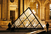 Paris. 1st district. Louvre Museum by night. One of the secondary pyramids (architect: Ieoh Ming Pei). Tourists in the foreground.Mandatory credit of the architect architect: Ieoh Ming Pei