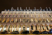 Paris. 1. Bezirk. Der Tuileriengarten bei Nacht. Rivoli-Straße. Gebäudefassaden mit darunter geparkten Autos.