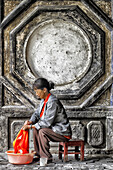 China, Provinz Yunnan, Baisha. Frau wäscht ihre Kleidung.