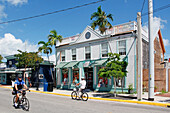 USA. Florida. The Keys. Key West. Historic and tourist center. Tourist and police officer riding bicycle.