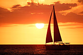 USA. Florida. Naples. The Pier. The beach. Sunset. Sailboat in the foreground.