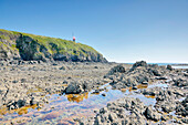 France. Normandy. Department of Manche. Granville during the summer. View of the coast and the lighthouse at ebb tide.