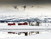 Norwegen,Stadt Tromso,rote Schuppen in einer verschneiten Landschaft