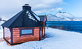 Norwegen,Stadt Tromso,Insel Senja,Saunahütte im Schnee am Rande des Fjordes