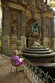France,Paris,6 th district,Luxembourg Gardens,seating woman drawing theMedici fountain.