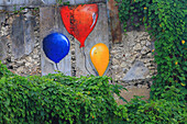 Straßenkunst. Bunte Luftballons an einer alten Mauer.