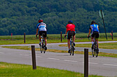 Three cyclists on a country road