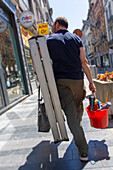 Repairman with a ladder and his tools on the street
