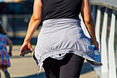 Woman from the back doing sports,phone and bottle of water in her hand