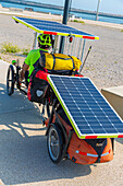 Reisende mit Dreirad mit Anhänger, ausgestattet mit Solarzellen