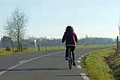 Frankreich,85,eine Frau auf einem Fahrrad auf einer Nationalstraße