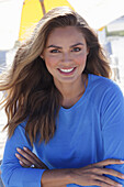 Woman in blue jumper sitting on the beach