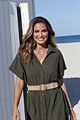 Woman in khaki coloured dress on the beach