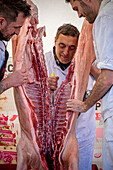 Butcher carving pig carcass