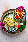 Cabbage pancakes with garlic sauce and tomato salad