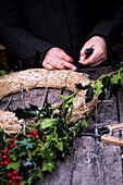 Herstellen von einem Weihnachtskranz aus Ilexzweigen und Stroh