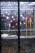 Weihnachtlicher Fensterschmuck mit gläsernen Kugeln und Kerzenständern im Wintergarten