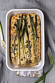 Focaccia with spring onions in a rectangular baking dish