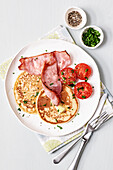 Potato pancakes with tomatoes and crispy bacon