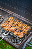 Chicken drumsticks in a grid on the grill