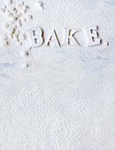 'BAKE' lettering dusted with icing sugar