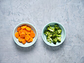Sliced carrots and broccoli florets in bowls
